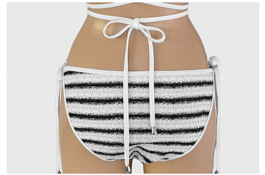 White and black striped bikini with triangle-cut top and tie-side bottom, modeled outdoors. - Image 24