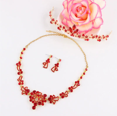 Red rhinestone bridal jewelry set featuring a floral necklace and matching dangle earrings on a model. - Image 11