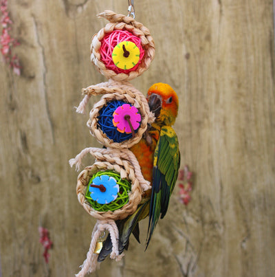 Colorful bird toy with three woven vine balls, internal pink, blue, and green string, felt flowers, and a bell. - Image 3