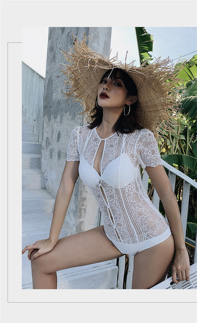 White lace cut-out one-piece swimsuit with short sleeves and a deep V-neckline, modeled by a woman. - Image 15