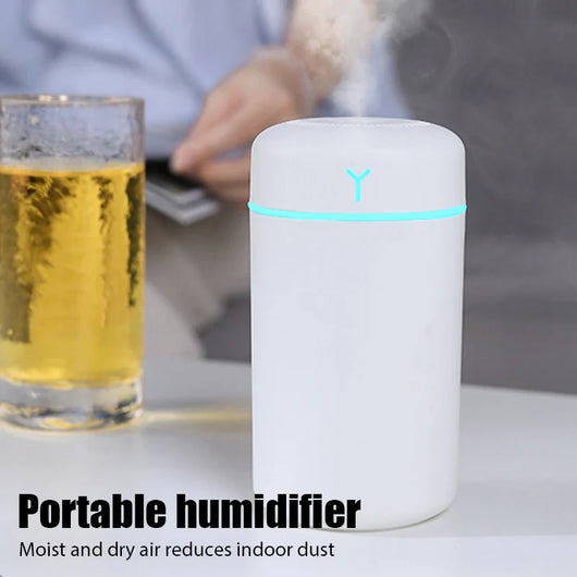 Pink portable humidifier with a blue LED light band, emitting fine mist, on a white pedestal. - Image 16
