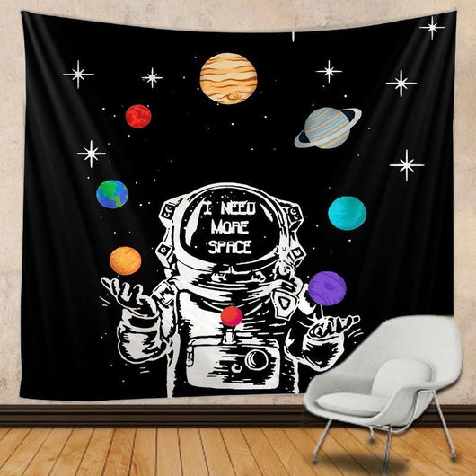 Black tapestry with a white astronaut juggling colorful planets and stars, featuring "I NEED MORE SPACE" text.