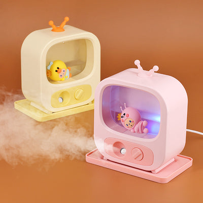 Pink TV-shaped desktop humidifier with a cute pink caterpillar figure inside, featuring a mist outlet and control knob.
