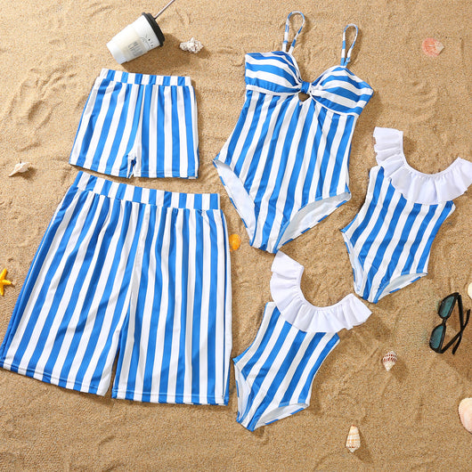 Blue and white striped one-piece swimsuit with a bow detail on the bust, laid on sand with sunglasses. - Image 16