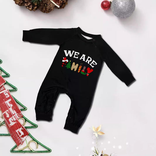 Family of four wearing matching black long-sleeve pajamas with "WE ARE FAMILY" text and black and white plaid bottoms. - Image 4