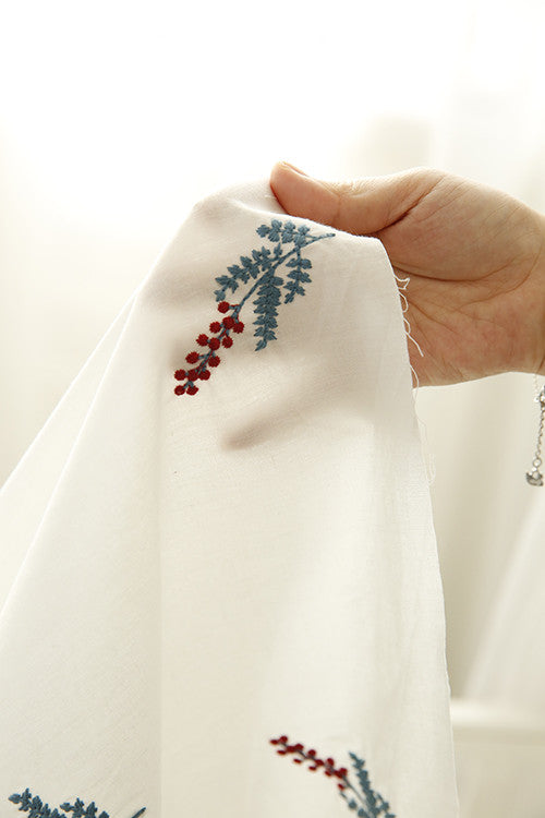 White pure cotton fabric with embroidered red cherries and green leaves, draped to show texture. - Image 3