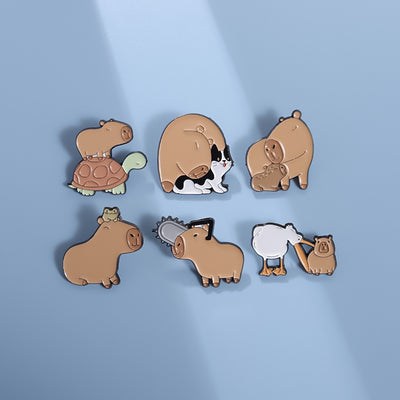 Cute capybara enamel brooch wearing a pink donut with sprinkles and "DONUT WORRY BE CAPPY" text. - Image 37