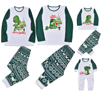 Woman in a Christmas pajama set with a white top, green sleeves, dinosaur graphic, and green fair isle pants. - Image 3