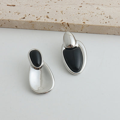 Pair of gold-toned irregular earrings with black onyx-like inserts, featuring a modern, abstract design. - Image 29