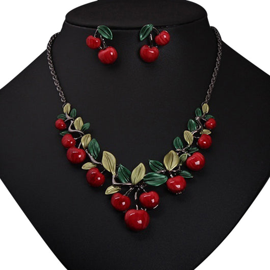 Cherry necklace and earring set featuring red enamel cherries and green leaves on a dark chain, displayed on a black bust. - Image 9