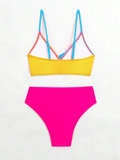 Woman wearing a blue color block split swimsuit with a wrapped front bikini top and high-waisted briefs. - Image 12