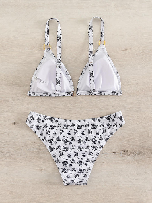 Woman smiling in a white bikini with blue floral print, triangle top, and briefs bottoms, on a sunny beach. - Image 22