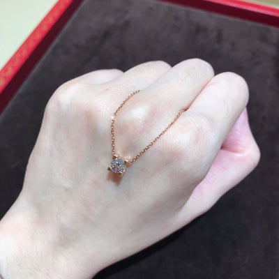 Delicate silver-colored chain necklace with a single square-cut clear stone pendant in a four-prong setting on a woman's neck. - Image 6