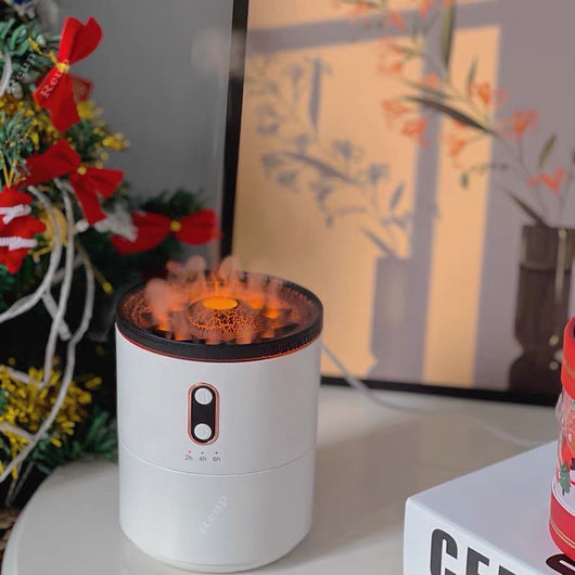 White volcanic flame aroma essential oil diffuser emitting orange light and mist on a wooden desk next to a laptop. - Image 6