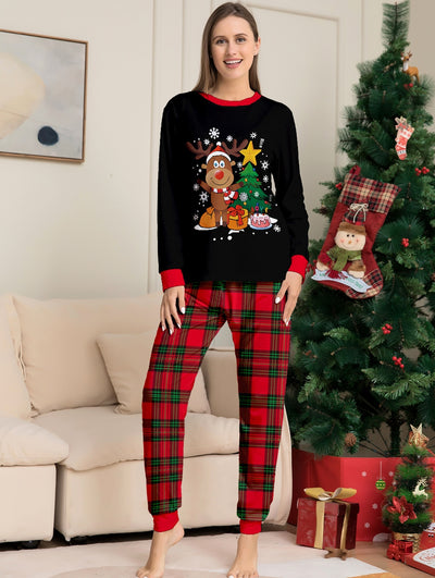 Two children in black and red plaid Christmas pajamas with a reindeer and Christmas tree graphic, standing by a Christmas tree. - Image 10