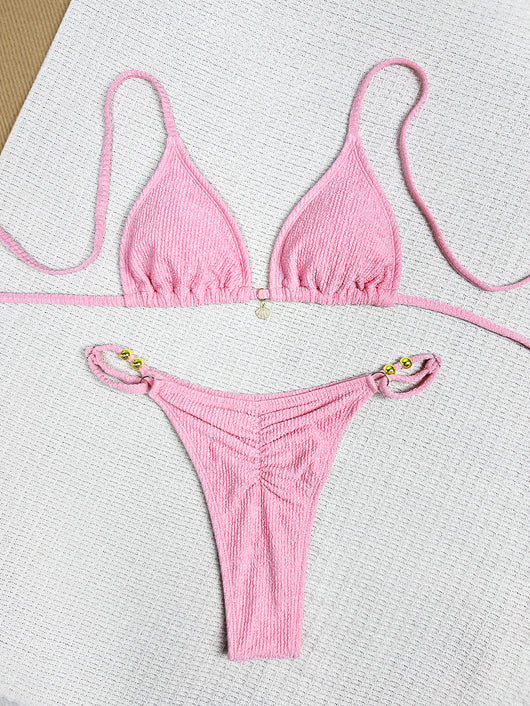 Pink textured halter bikini swimsuit with gold beads and a shell charm, worn by a woman on a wooden surface. - Image 12