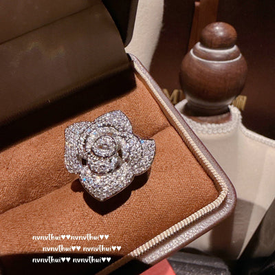 Pair of sparkling rose-shaped stud earrings, encrusted with clear gemstones, displayed in a brown jewelry box. - Image 12