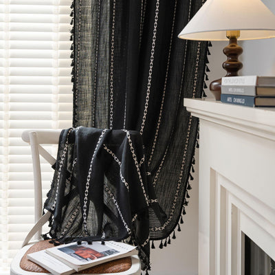 Black polyester curtain with white jacquard multi-line pattern and black tassels, draped over a white chair. - Image 4