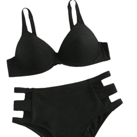 Dark green hard cup bikini with high-waisted bottoms featuring side cut-outs, worn by a woman lying on a bed. - Image 3