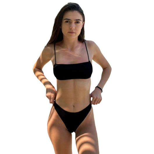 Woman in a blue banded bikini with a circular pattern standing on a sandy beach with clear water and green hills. - Image 11