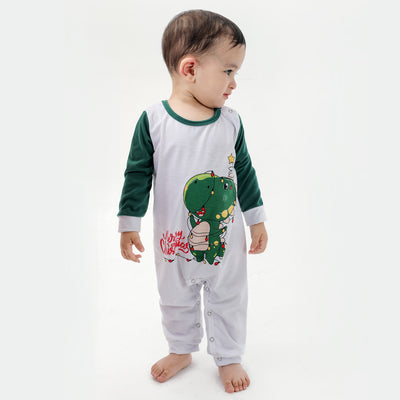 Woman in a Christmas pajama set with a white top, green sleeves, dinosaur graphic, and green fair isle pants. - Image 12