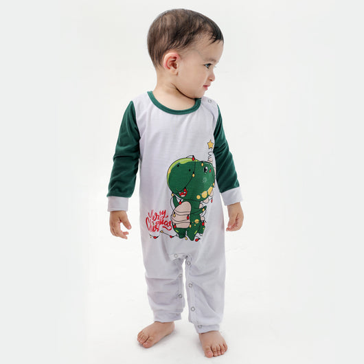 Woman in a Christmas pajama set with a white top, green sleeves, dinosaur graphic, and green fair isle pants. - Image 12