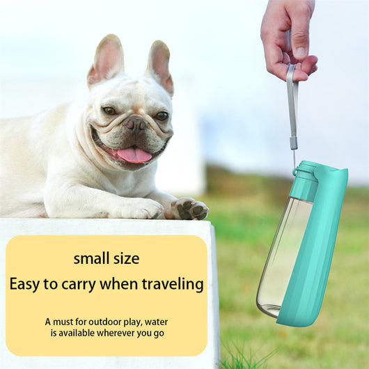 Yellow 450ml portable pet water bottle with a folding drinking trough and white wrist strap, on grass. - Image 16