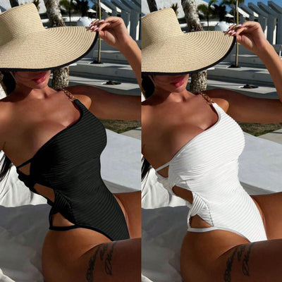 Woman in a black one-piece swimsuit with an asymmetrical one-shoulder design and side cut-outs, wearing a wide-brim straw hat, relaxing outdoors. - Image 2