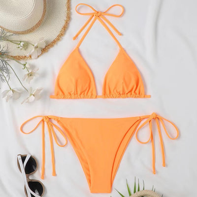 Neon yellow halter bikini with triangle top and tie-side bottoms, displayed on a light wood surface. - Image 18