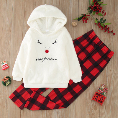 Family of four wearing matching cream fleece reindeer pajamas with red plaid pants, posing for a Christmas photo. - Image 21