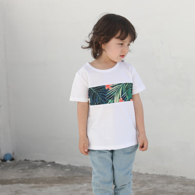 Child's white short-sleeve t-shirt with a horizontal tropical leaf and orange flower print band across the chest. - Image 7