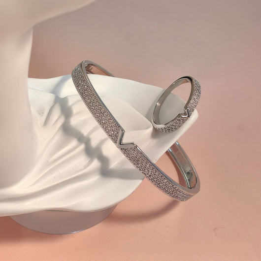 V-shaped 18K gold electroplated bracelet and ring set with pave clear stones on a white stand. - Image 7