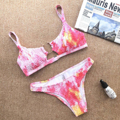 Red pleated cutout bikini set with a triangle top and thong bottom, displayed with yellow sunglasses and white flowers. - Image 5