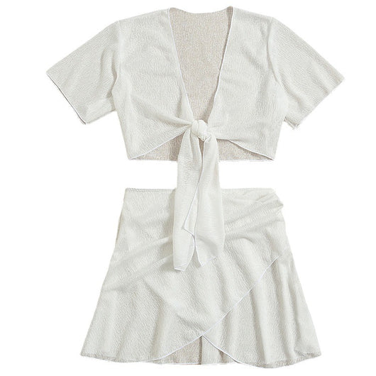 White two-piece swimwear set with a tie-front crop top and a high-waisted skirt with an asymmetrical ruffled hem. - Image 8