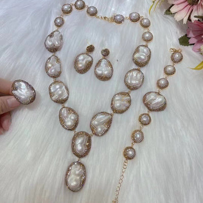 Baroque pearl necklace, ring, earrings, and bracelet set with gold-toned settings and sparkling accents.