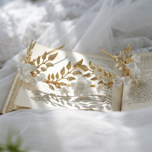 Silver-toned hair band with white ceramic flowers, faux pearls, and delicate silver leaves, perfect for bridal wear.