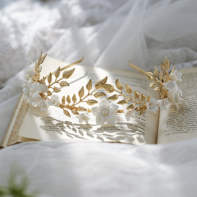 Silver-toned hair band with white ceramic flowers, faux pearls, and delicate silver leaves, perfect for bridal wear.