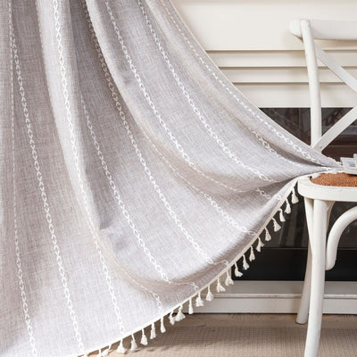 Black polyester curtain with white jacquard multi-line pattern and black tassels, draped over a white chair. - Image 11