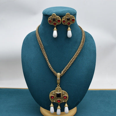 Vintage gold-toned necklace with double chain, ornate pendant featuring red and black glass inlays, and three white pearl tassels. - Image 8