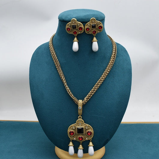 Vintage gold-toned necklace with double chain, ornate pendant featuring red and black glass inlays, and three white pearl tassels. - Image 8