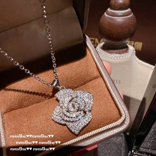 Pair of sparkling rose-shaped stud earrings, encrusted with clear gemstones, displayed in a brown jewelry box. - Image 14