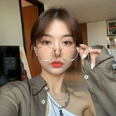 Retro square transparent full-frame glasses with blue light lenses, held by a person wearing grey sweatpants. - Image 3