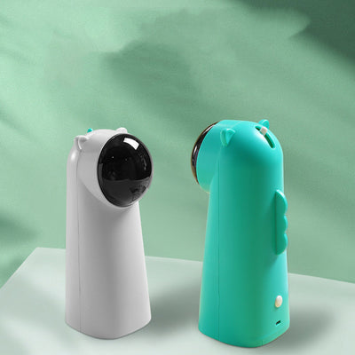 White automatic laser cat toy with a black dome projector and small cat ear details on top, featuring a green button.