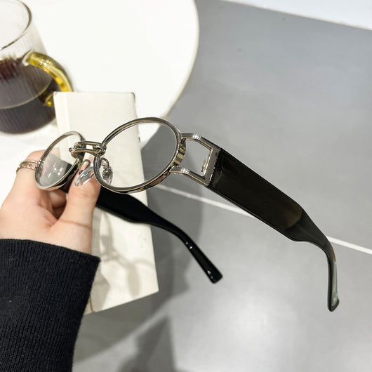 Retro small frame sunglasses with gold round frames and leopard print temples, held by a hand. - Image 10