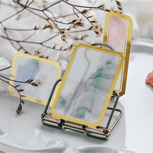 Assorted decorative paper labels with gold foil borders and soft watercolor designs in pink, blue, and green hues. - Image 5