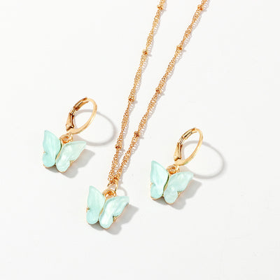 Blue resin butterfly necklace and earring set with gold-tone chains and findings, displayed on a light background. - Image 3