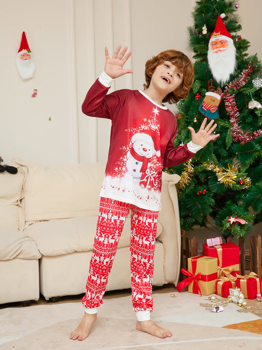 Family of four wearing matching red Christmas pajamas with snowman tops and reindeer fair isle pants, sitting by a Christmas tree. - Image 9