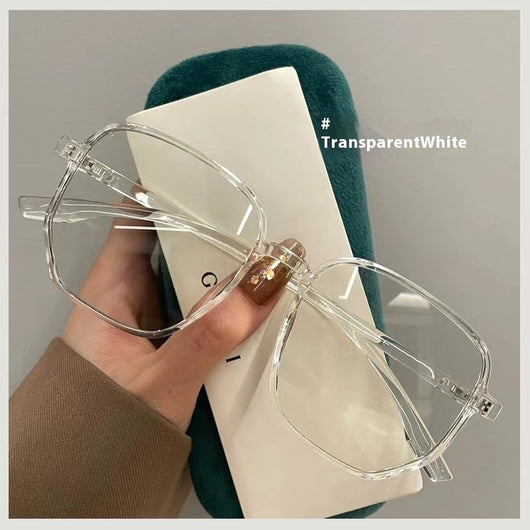 Mocha brown irregular frame glasses with clear lenses, held over a dark green velvet glasses case. - Image 9