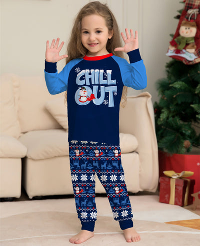 Family of four wearing matching blue and navy Christmas pajamas with 'CHILL OUT' snowman and snowflake patterns. - Image 3