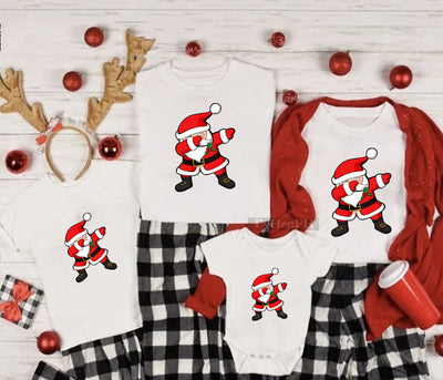 Family matching white Christmas t-shirts and baby bodysuit with 'Merry Christmas' graphic, paired with black and white plaid pajama bottoms. - Image 12